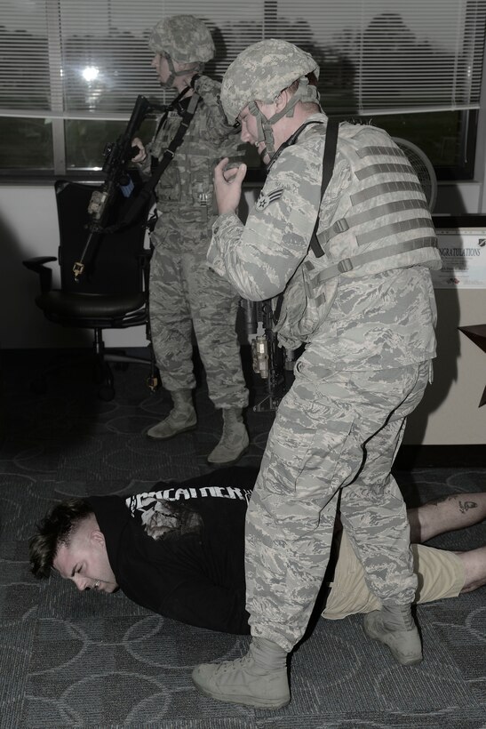 U.S. Airmen assigned to the 633rd Security Forces Squadron apprehend a suspect during an active shooter exercise at Langley Air Force Base, Va., Nov. 19, 2015. Active shooter exercises tests unit’s abilities to respond with a mass casualty incident at Langley. (U.S. Air Force photo illustration by Staff Sgt. Ciara Gosier)