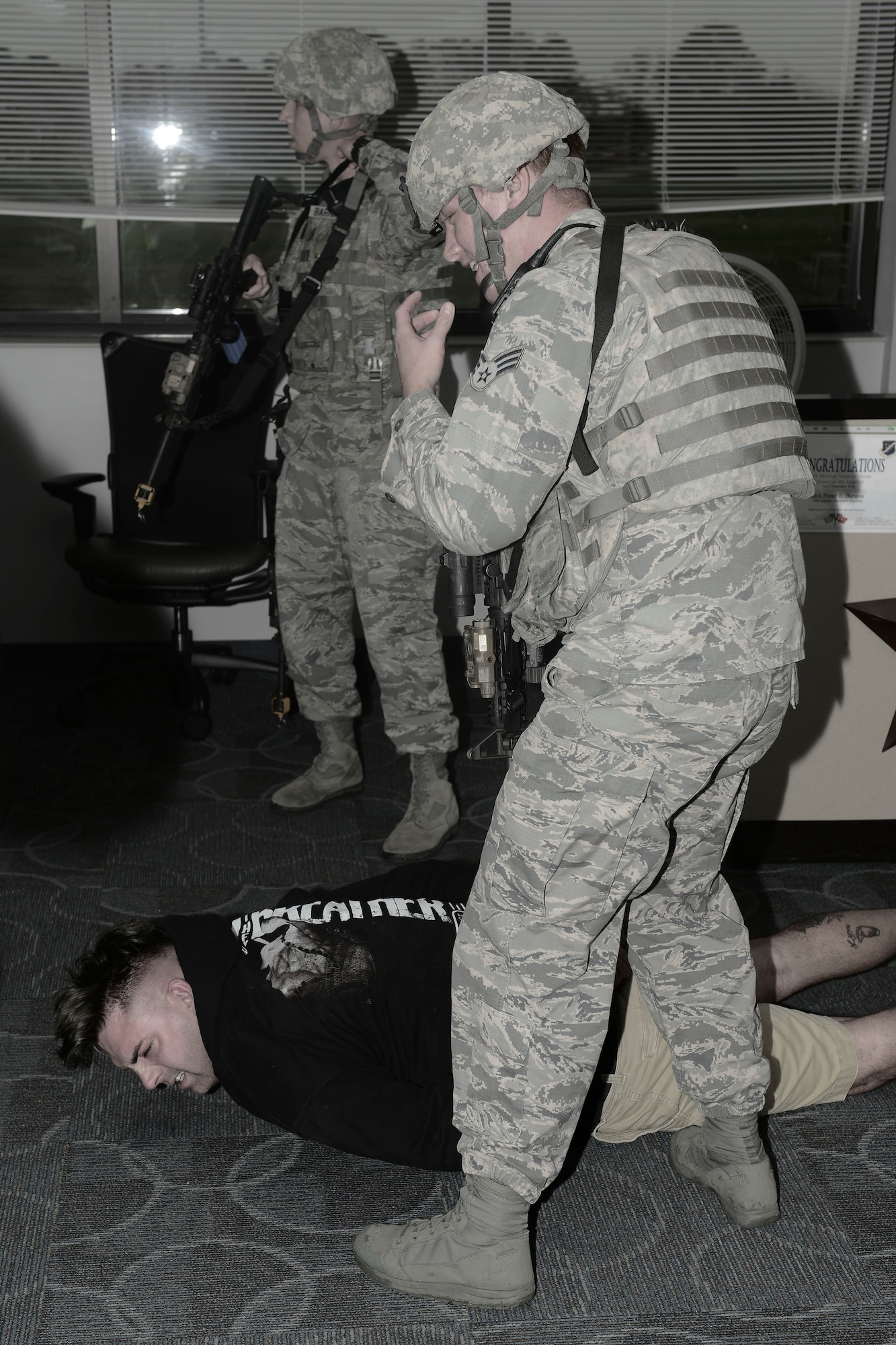 U.S. Airmen assigned to the 633rd Security Forces Squadron apprehend a suspect during an active shooter exercise at Langley Air Force Base, Va., Nov. 19, 2015. Active shooter exercises tests unit’s abilities to respond with a mass casualty incident at Langley. (U.S. Air Force photo illustration by Staff Sgt. Ciara Gosier)