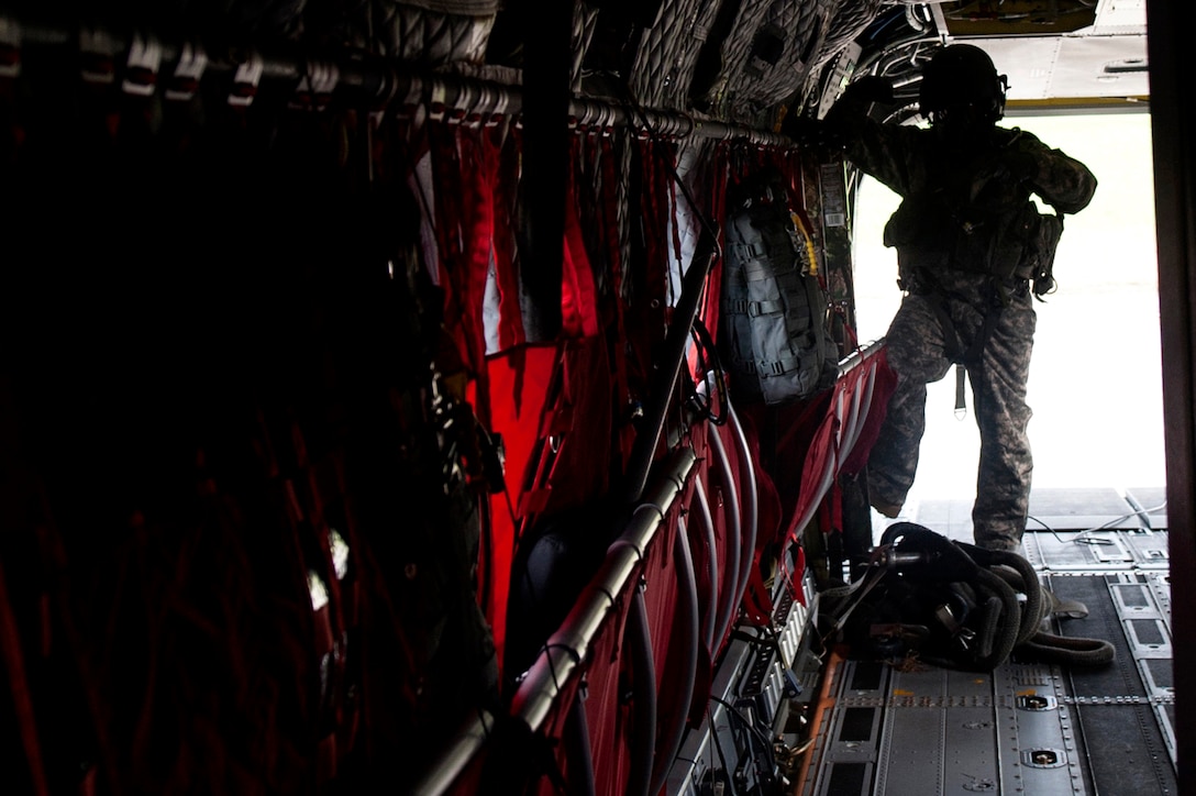 U.S. Army Staff Sgt. Job Smith, a crew member assigned to B Company, 5th Battalion (General Support) Aviation, 159th Aviation Regiment, waits for his next instruction during a CH-47 Chinook training mission at Felker Army Air Field, Fort Eustis, Va., Nov. 18, 2015. The Chinook is designed to pick up equipment that doesn’t normally fit in Army aircraft, such as Humvees and large cargo because a Chinook can carry up to 50,000 pounds of gross weight. (U.S. Air Force photo by Senior Airman Breonna Veal) 