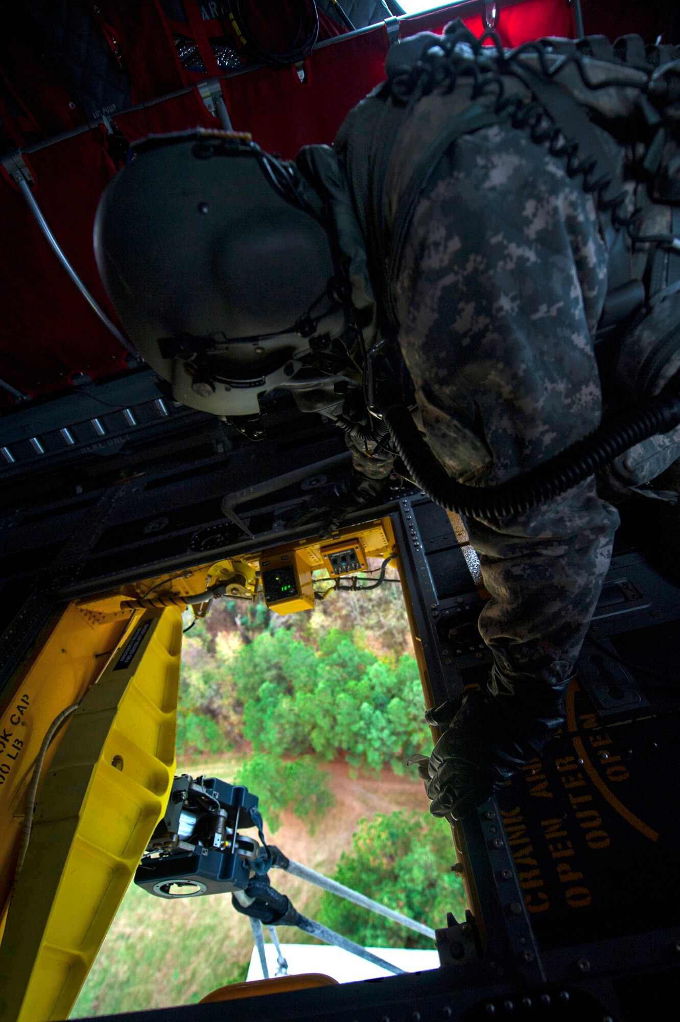 U.S. Army Cpl. Terrence Patterson, a crew member assigned to B Company, 5th Battalion (General Support) Aviation, 159th Aviation Regiment, observes a sling load during a training mission at Felker Army Air Field, Fort Eustis, Va., Nov. 18, 2015. During a sling load mission, cargo, which weighed approximately 8,700 pounds, is picked up by a clevis hook, tightened and lifted off the ground by a CH-47 Chinook. (U.S. Air Force photo by Senior Airman Breonna Veal)