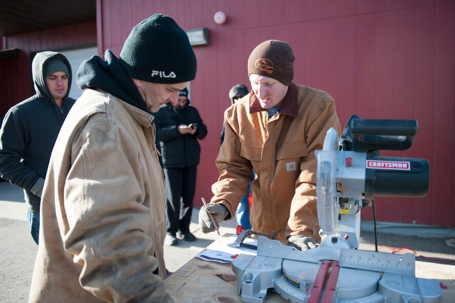 Led by the 5th Security Forces Squadron and 5th Civil Engineering Squadron, members from Minot Air Force Base teamed up with Souris Valley Animal Shelter to build a new roof over the outdoor kennels in Minot, N.D., Nov. 21, 2015. The new roof replaced a rotting roof that's used to protect the animals while they get fresh air and a holding place while their indoor kennels are cleaned. (U.S. Air Force photo by 2nd Lt. Kylee Ashton)