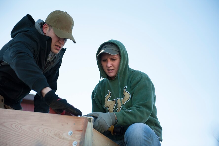 Led by the 5th Security Forces Squadron and 5th Civil Engineering Squadron, members from Minot Air Force Base teamed up with Souris Valley Animal Shelter to build a new roof over the outdoor kennels in Minot, N.D., Nov. 22, 2015. The new roof replaced a rotting roof that's used to protect the animals while they get fresh air and a holding place while their indoor kennels are cleaned. (U.S. Air Force photo by 2nd Lt. Kylee Ashton)
