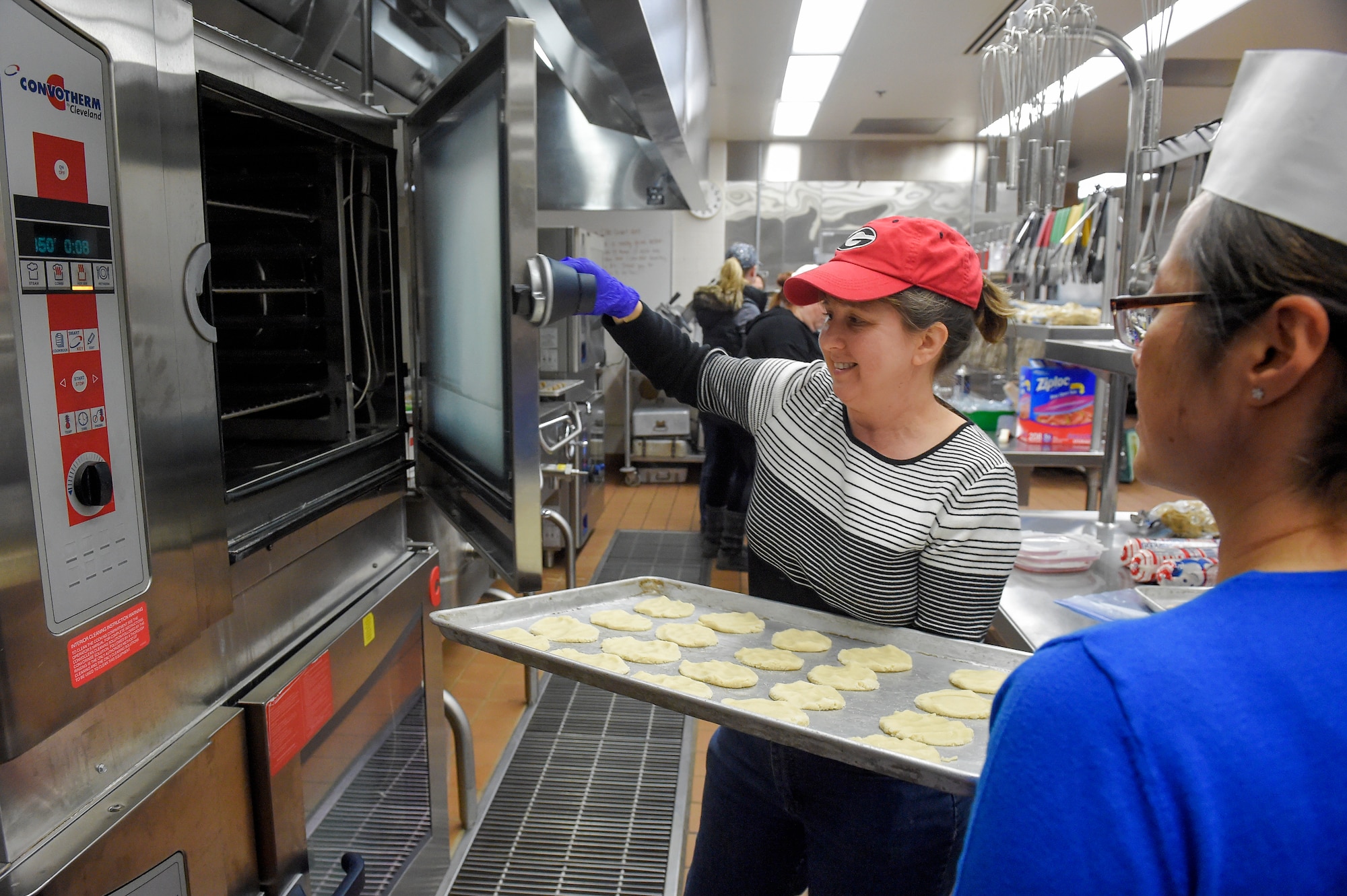 Volunteers bake thousands of cookies utilizing the Wolf's Den dining facility kitchen on Joint Base Elmendorf-Richardson, Alaska, Nov. 17, 2015. During the cookie drive volunteers collected dough, baked, sorted and packaged the cookies. The cookies will later be delivered to single Airmen and Soldiers living in the dorms and barracks to provide them with a homemade treat during the holiday season. (U.S. Air Force photo/Alejandro Peña)