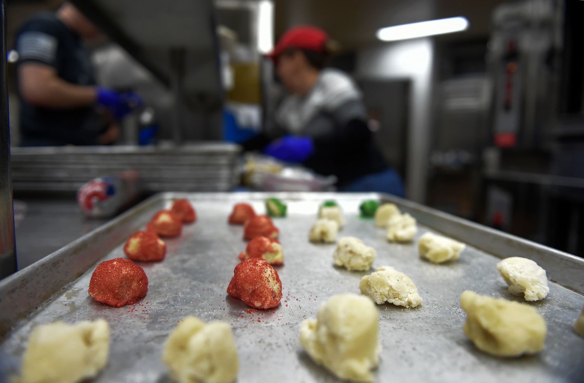 Volunteers bake thousands of cookies utilizing the Wolf's Den dining facility kitchen on Joint Base Elmendorf-Richardson, Alaska, Nov. 17, 2015. During the cookie drive volunteers collected dough, baked, sorted and packaged the cookies. The cookies will later be delivered to single Airmen and Soldiers living in the dorms and barracks to provide them with a homemade treat during the holiday season. (U.S. Air Force photo/Alejandro Peña)