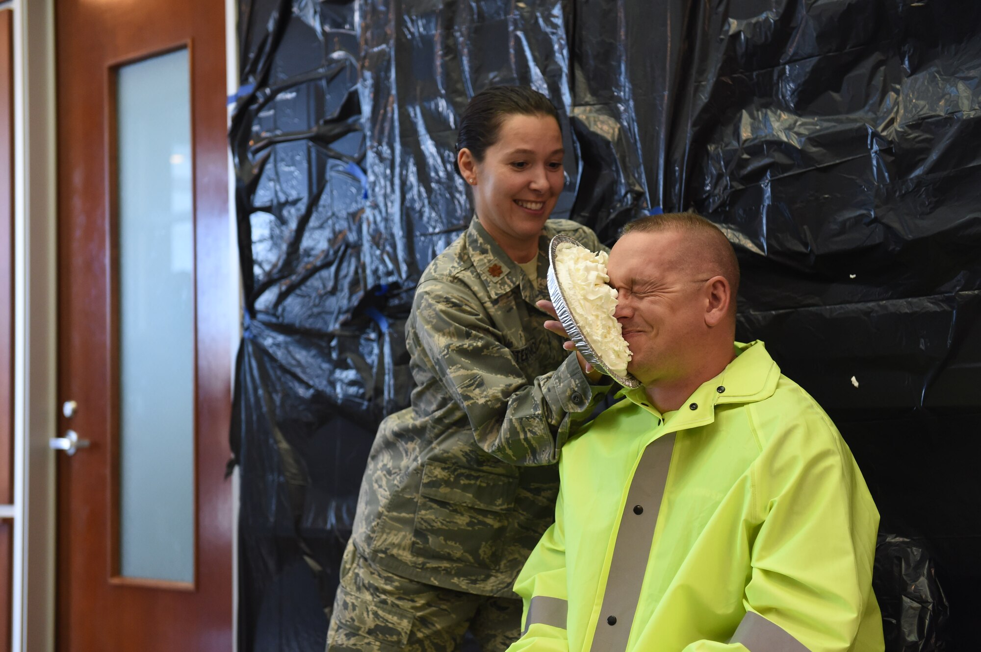 Lt. Col. Paul Freeman, 460th Space Wing chief of safety, takes a pie in the face from Maj. April Reveteriano, 460th Space Wing Individual Mobilization Augmentee to the chief of safety, as a fundraiser for the Combined Federal Campaign Nov. 20, 2015, on Buckley Air Force Base, Colo. Buckley AFB held Wingman Day in order to recognize the men and women who continue the mission of the 460th Space Wing each and every day. (U.S. Air Force photo by Airman 1st Class Luke W. Nowakowski/Released)