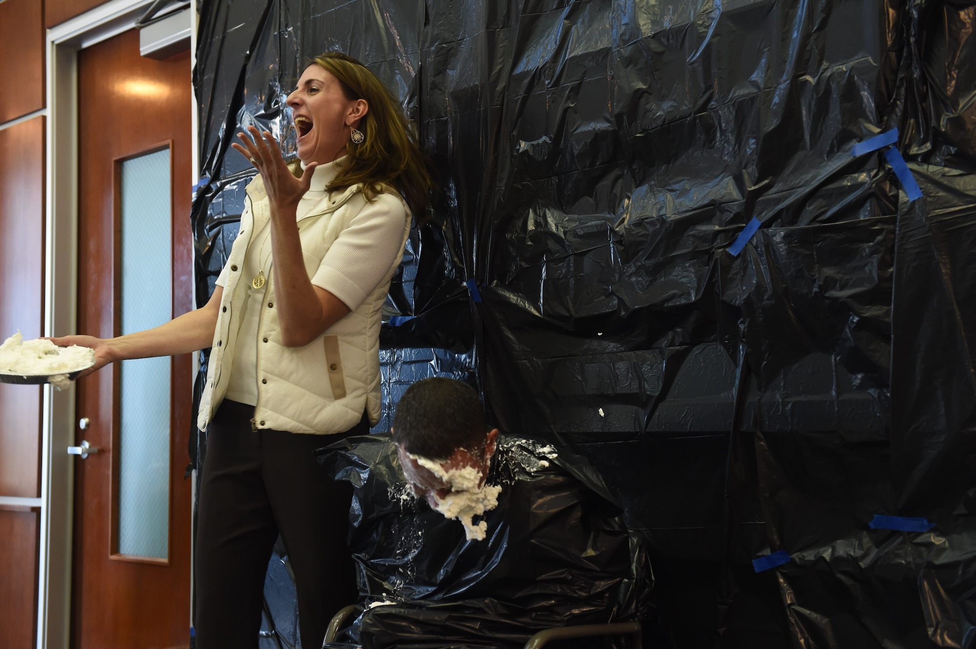 Chief Master Sgt. Brian Kruzelnick, 460th Space Wing command chief, takes a pie in the face from Christina Grooms, 460th Space Wing community support coordinator, as a fundraiser for the Combined Federal Campaign Nov. 20, 2015, on Buckley Air Force Base, Colo. Buckley AFB held Wingman Day in order to recognize the men and women who continue the mission of the 460th Space Wing each and every day. (U.S. Air Force photo by Airman 1st Class Luke W. Nowakowski/Released)