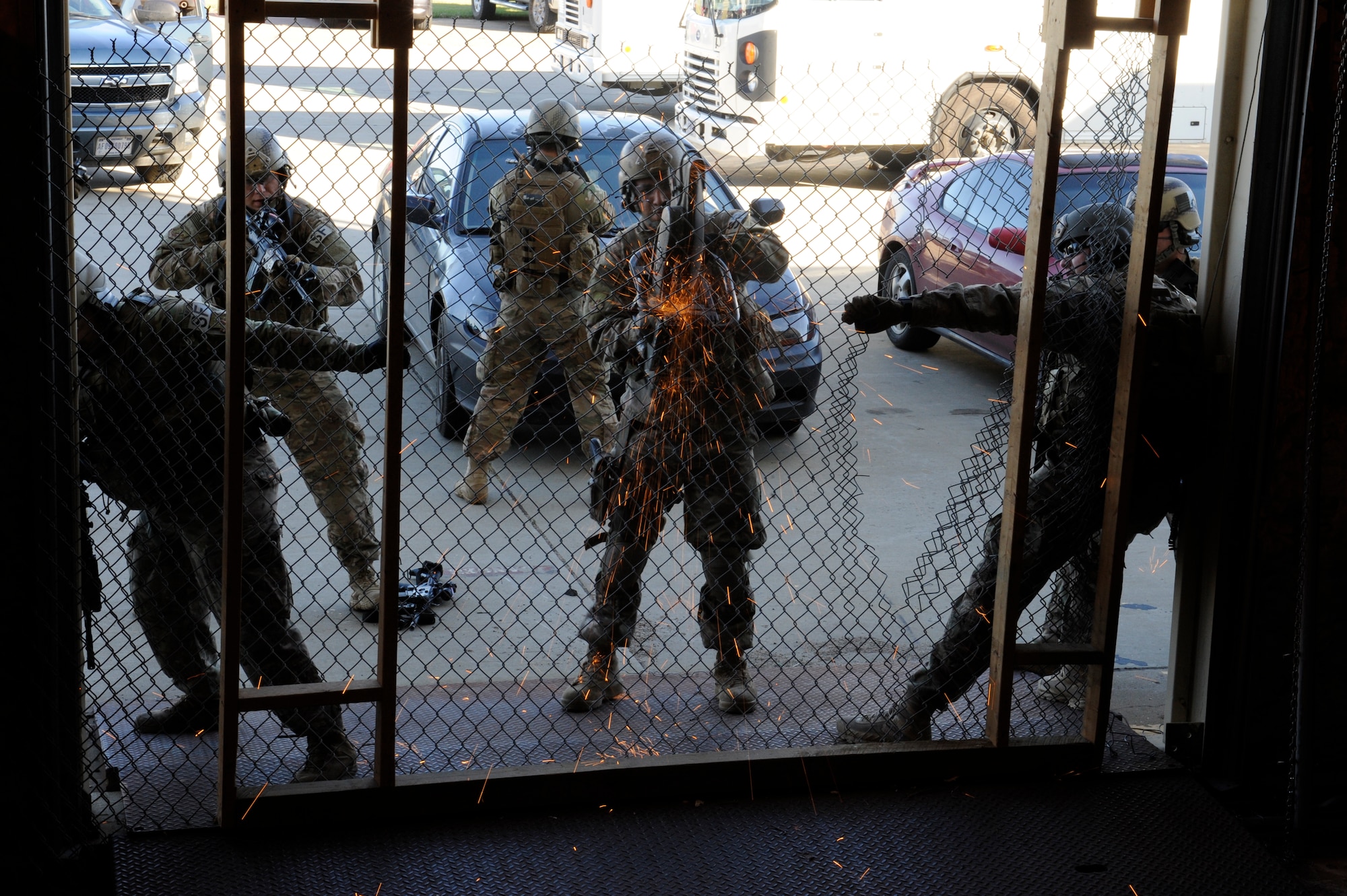 791st Missile Security Forces Squadron tactical response force members cut a fence at Minot Air Force Base, N.D., Oct. 14, 2015. Upon reaching the compound, breachers are responsible for using tools such as the K12 saw to allow for access. (U.S. Air Force photo/Airman 1st Class Sahara L. Fales)