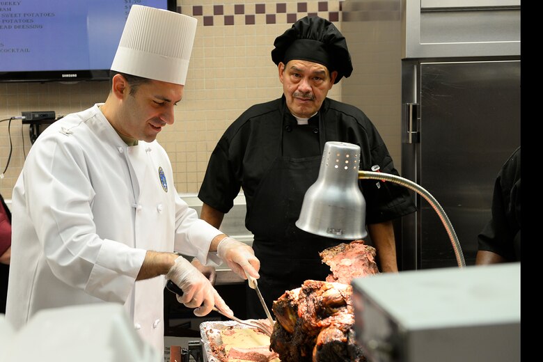 Col. Jason Janaros, 50th Mission Support Group commander, carves a leg of beef in preparation of a holiday meal at the Satellite Dish Dining Facility at Schriever Air Force Base, Colorado, Wednesday, Nov. 18, 2015. During the Thanksgiving four-day weekend, members not in leave status must be able to report for duty within eight hours of a recall notice. (U.S. Air Force photo/Christopher DeWitt)