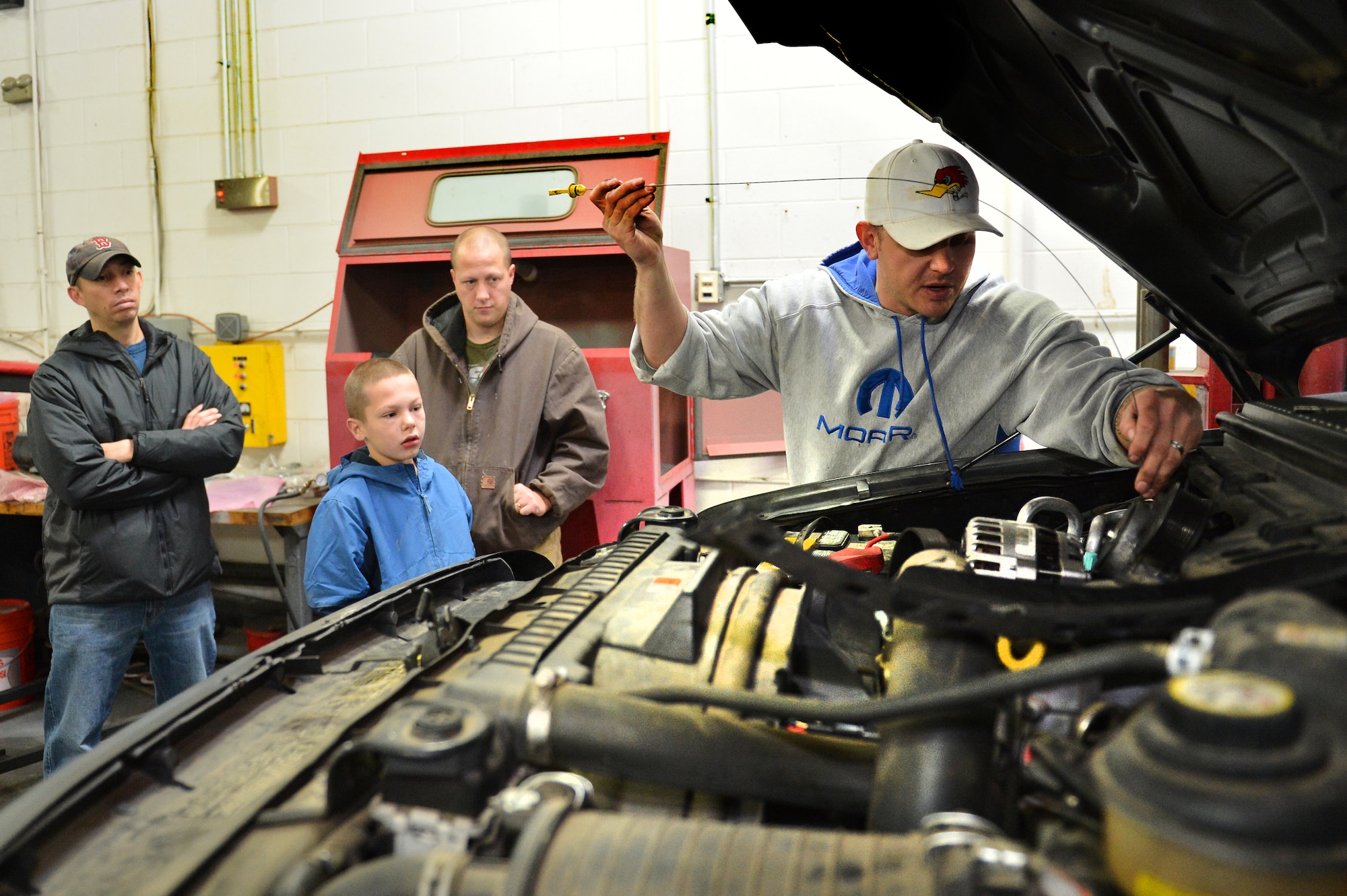 Tech. Sgt. Andrew Wanzer, 460th Logistics Readiness Squadron NCO in charge of logistics plans, demonstrates how to check oil in a vehicle as part of his Automotive 101 class Nov. 21, 2015, on Buckley Air Force Base, Colo. The class teaches basic skills to safely maintain a motor vehicle and is set to take place once a month. (U.S. Air Force photo by Staff Sgt. Darren Scott/Released)