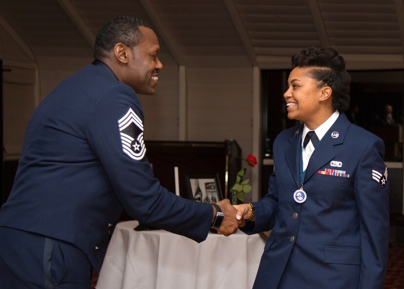 Chief Master Sgt. Omar D. Hardman, superintendent of the 66th Medical Squadron, congratulates Senior Airman Sabine O. Bien-Aime, 66th Air Base Group administration specialist, on completing Airman Leadership School during the graduation ceremony at the Minuteman Commons Nov. 20. Twelve soon-to-be NCOs completed the five-week professional military education class designed to develop junior enlisted members into effective front-line supervisors. (U.S. Air Force photo by Mark Herlihy)