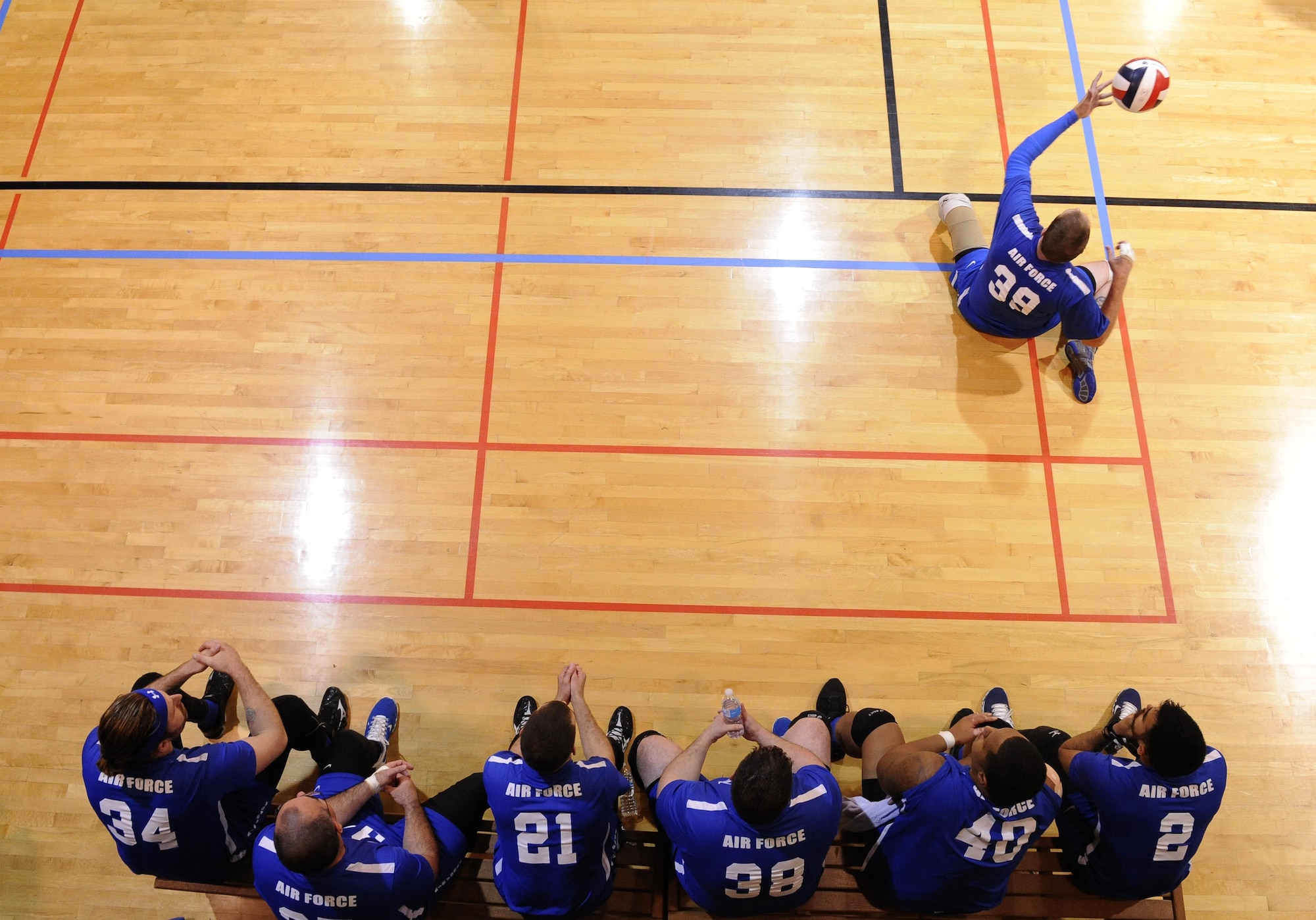 Members of the Air Force wounded warriors volleyball team watch as retired Tech. Sgt. Patrick Young serves the ball during a volleyball match as part of the Warrior Care Month Sitting Volleyball Tournament at the Pentagon in Washington, D.C., Nov. 19, 2015. The Air Force Wounded Warrior Team won the match against the Marines, and went on to take home the trophy for the tournament. (U.S. Air Force photo/Staff Sgt. Whitney Stanfield)