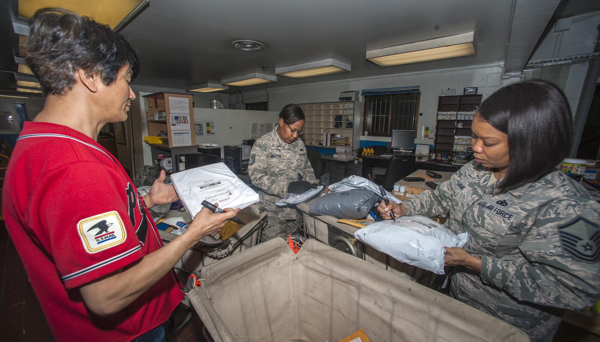 Chongonn Won, Tech. Sgt. Alethea Keaton and Master Sgt. Renee Williams, all post office staff members, organize mail  at Kunsan Air Base, Republic of Korea, Nov. 24, 2015. To accommodate service members during the holiday season, the post office is extending their hours to 9:30 a.m. to 5:30 p.m. on Monday – Friday and 10 a.m. to 2 p.m. on Saturdays from Nov. 23 to Jan. 2. (U.S. Air Force courtesy photo/Released)