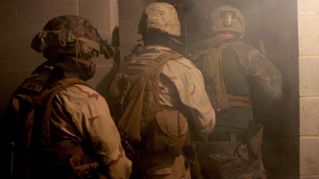 A Marine Raider with 1st Marine Raider Battalion and two Marines with 2nd Combat Engineer Battalion prepare to clear a building during a night raid at the Combined Arms Collective Training Facility at Camp Shelby, Miss., Nov. 17.  The raid was part of a 10-day exercise in the Gulf Coast region to maintain unit readiness. The 2nd CEB Marines participated in the U.S. Marine Corps Forces, Special Operations Command exercise to strengthen and enhance Special Operations Forces and Marine Air Ground Task Force interoperability.