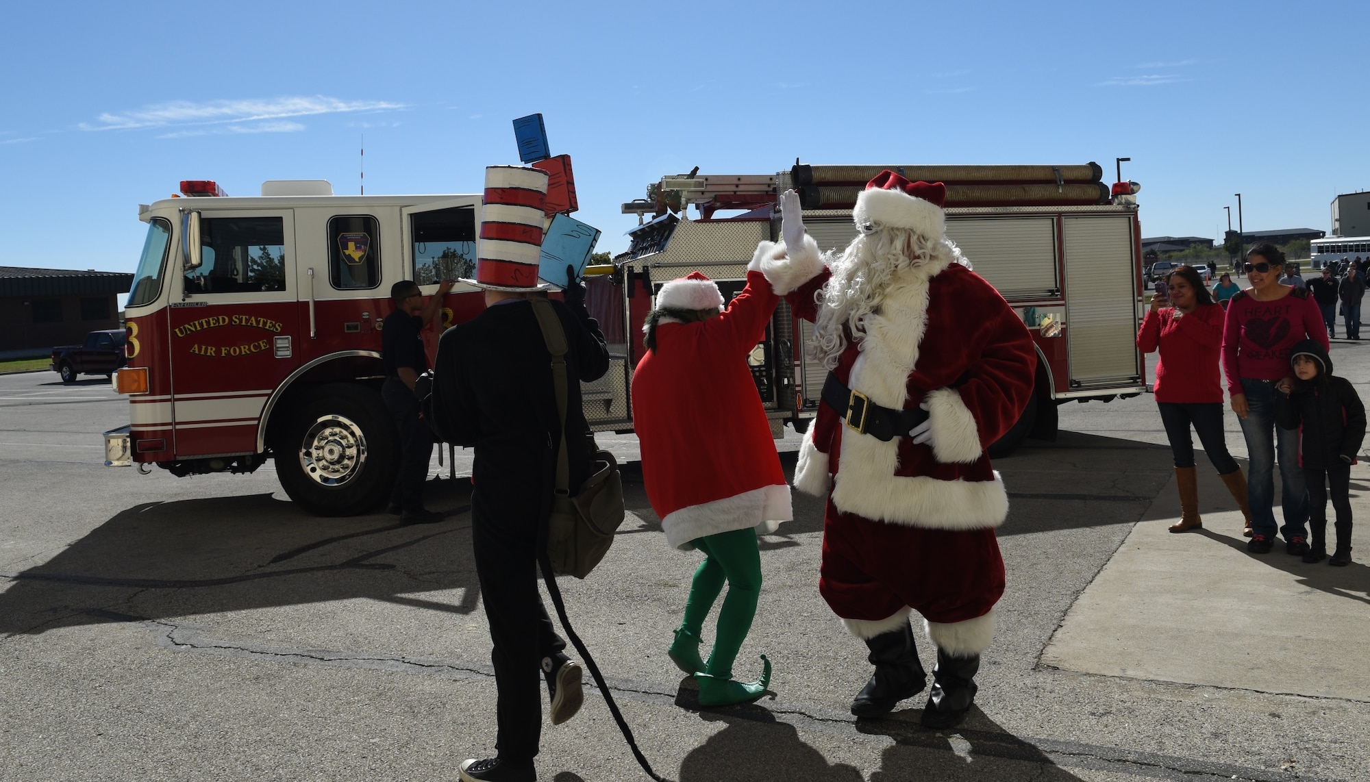 Santa and the Grinch high five each other during the 7th Annual Goodfellow Community Appreciation Day outside the fire school high bay on Goodfellow Air Force Base, Texas, Nov. 21, 2015. The Grinch and Santa switched out sitting with kids for photo opportunities. (U.S. Air Force photo by Staff Sgt. Laura R. McFarlane/Released)