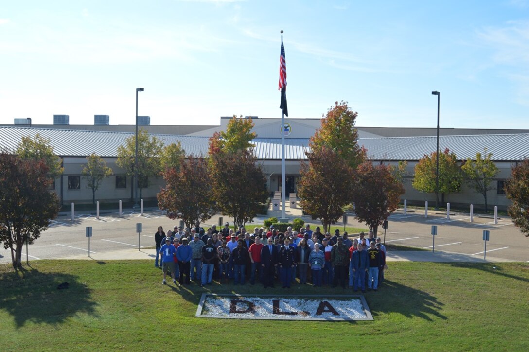 DLA Distribution Red River, Texas, veteran employees gather for a group photo during a Veterans Day program on Nov. 10.