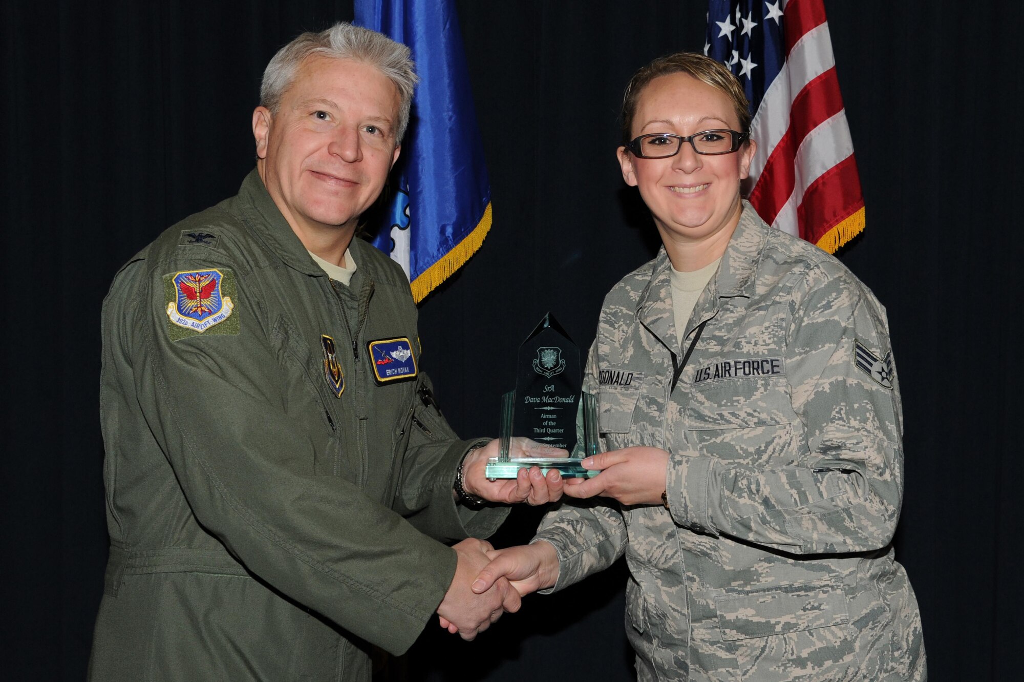PETERSON AIR FORCE BASE, Colo. – Senior Airman Dava MacDonald (right), an Emergency Action Controller and 302nd Airlift Wing Reservist assigned to with the Colorado Springs Regional Command Post, was presented the 302nd AW Airman of the Third Quarter award by Col. Erich Novak on Nov. 15, 2015 here. Novak, 302nd Airlift Wing vice commander, and Chief Master Sgt. Otis Jones, 302nd Airlift Wing command chief recognized the 2015 quarterly award winners during the November Unit Training Assembly. (U.S. Air Force photo/Senior Airman Amber Sorsek)