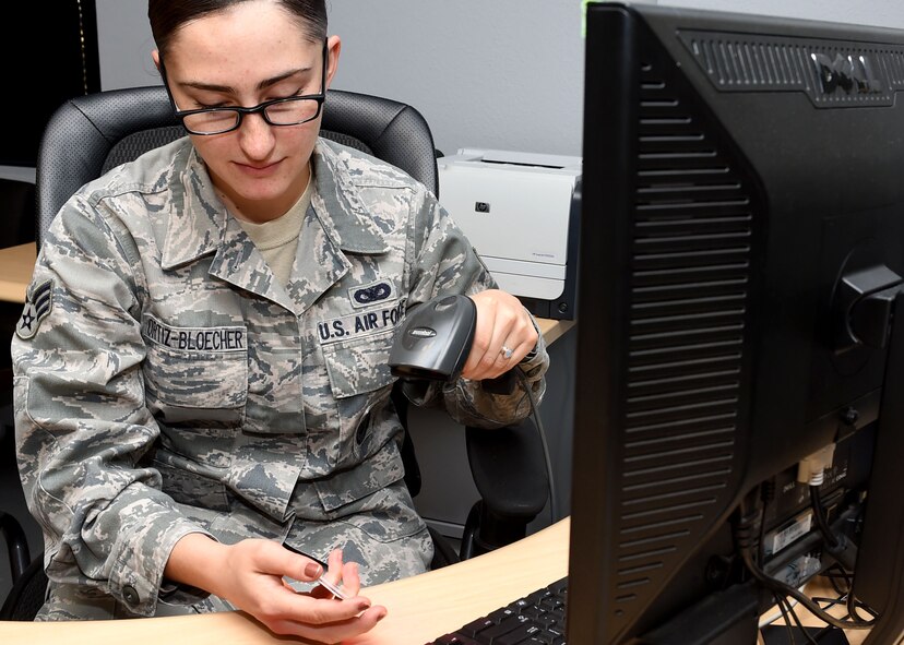 U.S. Air Force Senior Airman Katelyn Ortiz-Bloecher, 97th Security Forces Squadron Pass and Identification installation access clerk, scans an ID, Nov. 24, 2015, at the Pass and ID Office, Altus Air Force Base, Okla. The Pass and ID Office scans identification cards to check if individuals are already registered in the Defense Biometric Identification System or to assign a sponsor while they’re visiting Altus AFB. (U.S. Air Force photo by Senior Airman Franklin R. Ramos/Released)