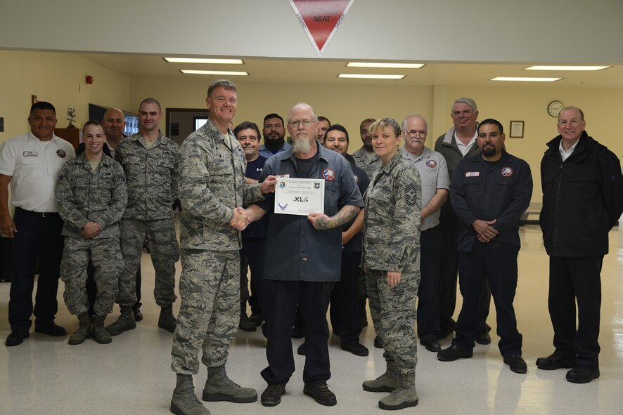 Lawerence Cartwright, center, 47th Maintenance Directorate aircraft ordnance mechanic, poses with Col. Thomas Shank, 47th Flying Training Wing commander and Chief Master Sgt. Teresa Clapper, 47th FTW command chief, after accepting the “XLer of the Week” award, here, Nov. 24, 2015. The “XLer” is a weekly award chosen by wing leadership and is presented to those who consistently make outstanding contributions to their unit and Laughlin. (U.S. Air Force photo by Airman 1st Class Brandon May) 