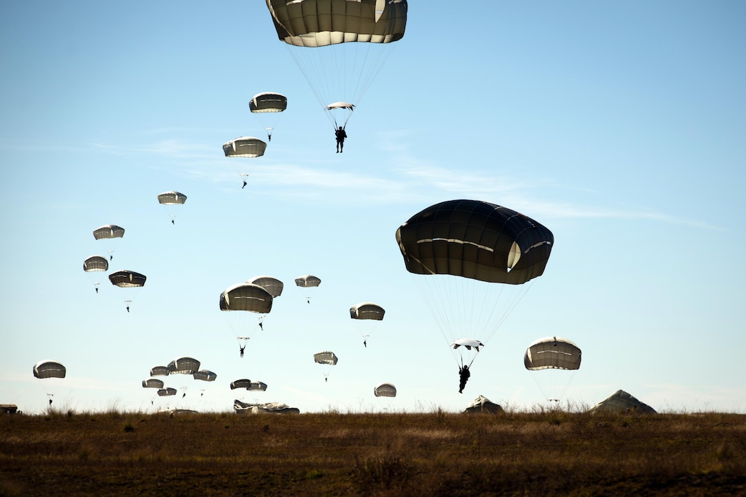 Army paratroopers descend to the ground at the Sicily drop zone on Fort Bragg, N.C., Nov. 21, 2015. The soldiers were participating in the Saturday Proficiency Jump Program, which aims to allow paratroopers to build additional proficiency and confidence for airborne operations. U.S. Army photo by Staff Sgt. Charles Crail