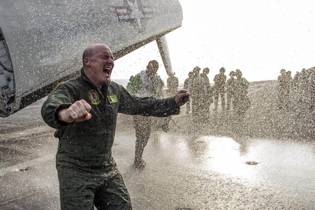 U.S. Navy Capt. Christopher Bolt reacts to being sprayed with a fire hose aboard the USS Ronald Reagan in celebration of his final arrested landing as the ship’s commanding officer in waters south of Japan, Nov. 22, 2015. The Ronald Reagan and its embarked air wing, Carrier Air Wing 5, provide a combat-ready force to protect and defend the collective maritime interests of the U.S. and its allies and partners in the Indo-Asia-Pacific region. U.S. Navy photo by Petty Officer 3rd Class Ryan McFarlane