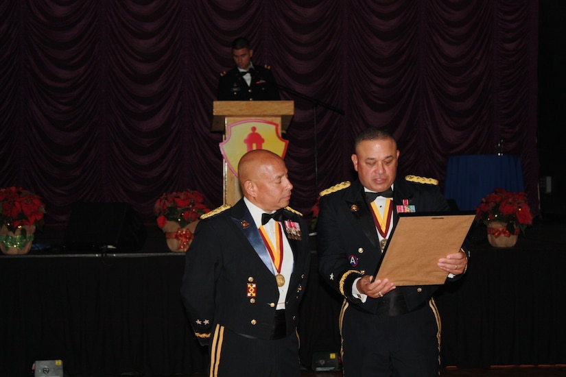 Brig. Gen. Jose R. Burgos, 1st MSC Commanding General, presents Maj. Gen. Luis R. Visot with a small memento of appreciation during the 2015 Military Ball at the Hilton Ponce Golf & Casino Resort in Ponce, Puerto Rico, Nov. 21, 2015.