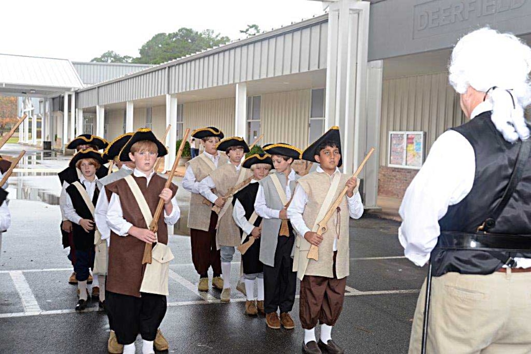 Kent Morrison, executive director, Marine Corps Logistics Base Albany, spends part of Nov. 19 helping fifth grade students at Deerfield-Windsor’s Lower School, Albany, Ga., learn about the American Revolution.