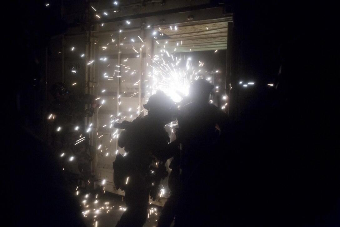 A Marine Raiders with Marine Special Operations Company  Charlie, 1st Marine Raider Battalion, U.S. Marine Corps Forces, Special Operations Command, breach a conex box with a saw during Visit, Board, Search and Seizure training, as part of a Company Collective Exercise, Oct. 15, 2015, in San Diego, Calif.
