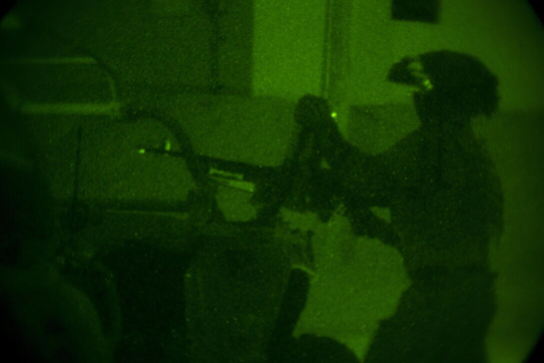 A Marine Raider with Marine Special Operations Company Charlie, 1st Marine Raider Battalion, U.S. Marine Corps Forces, Special Operations Command, lays down cover-fire and provides security to his team conducting a notional direct-action night raid, during a Company Collective Exercise, Oct. 18, 2015, aboard Marine Corps Base Twentynine Palms, Calif.