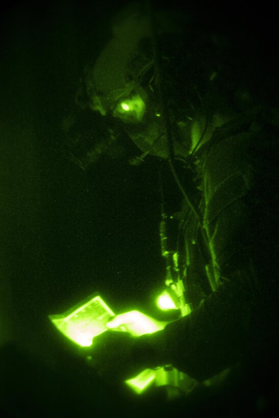 A Marine Raider with Marine Special Operations Company Charlie, 1st Marine Raider Battalion, U.S. Marine Corps Forces, Special Operations Command, references a map during a notional night operation, apart of a Company Collective Exercise, Oct. 20, 2015, along the Arizona-California state line.