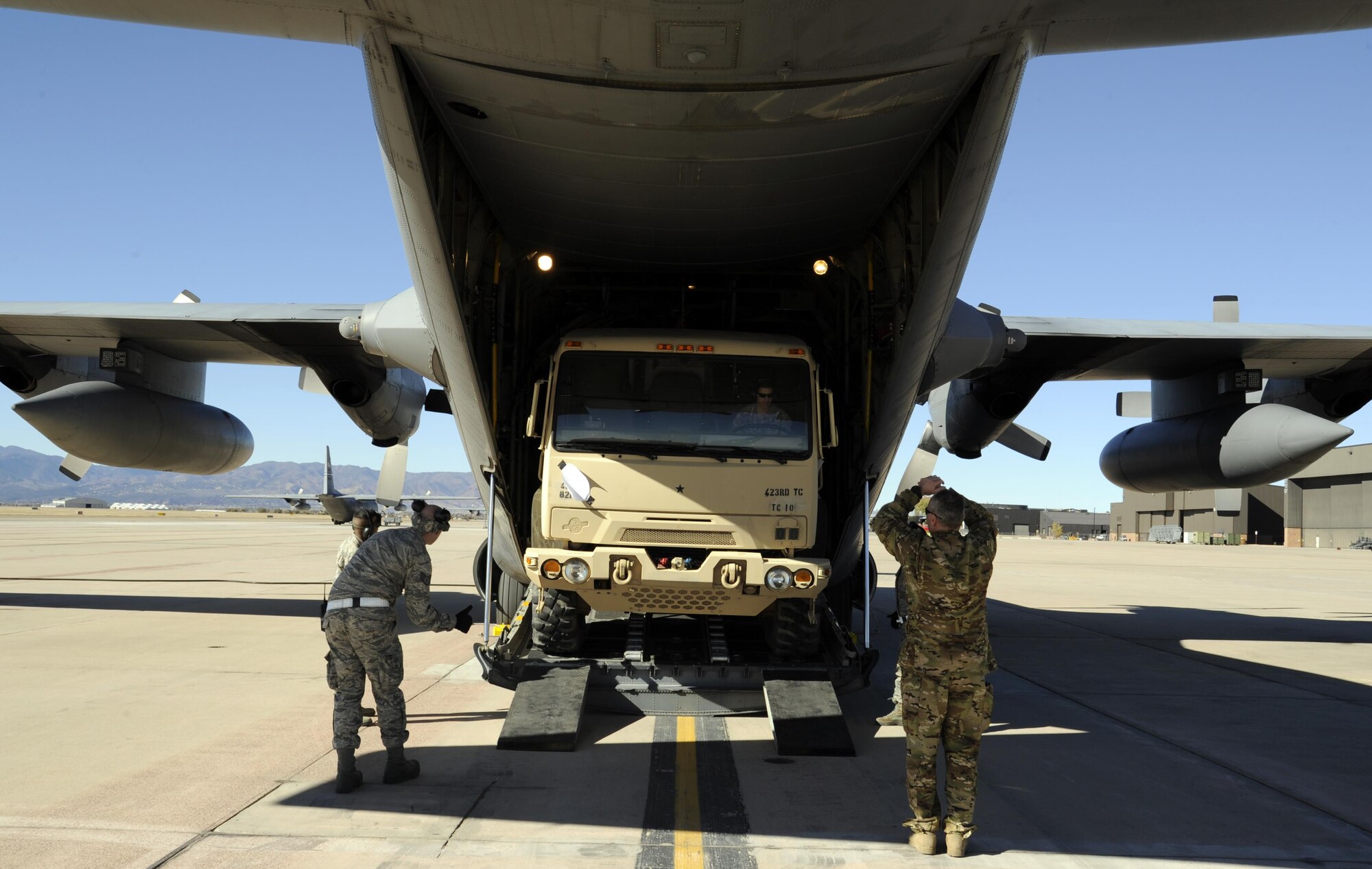 PETERSON AIR FORCE BASE, Colo. – A ramp specialist from the 39th Aerial Port Squadron and a C-130 loadmaster from the 731st Airlift Squadron, along with Army Reservists from the  423rd Transportation Company, Fort Carson, Colo., load a light medium tactical vehicle onto an Air Force Reserve C-130, Nov. 14, 2015 here. The joint training event was accomplished during the 302nd Airlift Wing’s November Unit Training Assembly. (U.S. Air Force photo/Staff Sgt. Nathan Federico)
