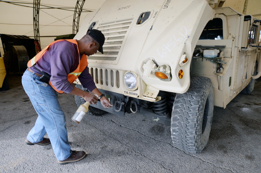 Freddie Grant, heavy mobile equipment repairer, Marine Corps Logistics Command, applies a protective lubricant to a vehicle recently while performing the level A preservation process. This is one step in an extensive process to help prevent deterioration of vehicles stored outside.