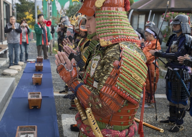 Marines and Japanese locals pray for the deceased samurai at the Kuragake Castle Festival in Kuga, Iwakuni, Japan, Nov. 22, 2015. The festival honors the local Kuga samurai who urged their castle lord to take a last stand against a much larger enemy force. Participants marched from the Kuga train station to the town square before they reenacted the final confrontation of the samurai who marched to battle in the 16th century.