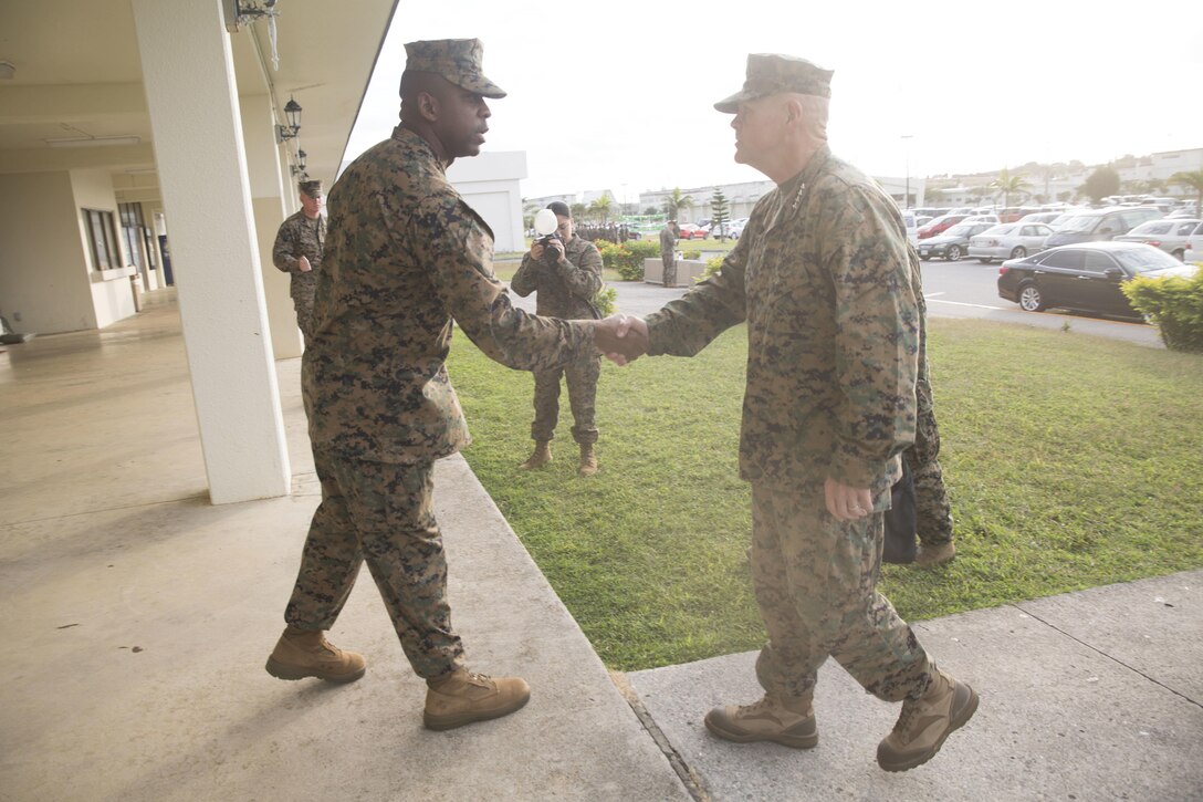 U.S. Marine Corps Sgt. Maj. Devon A. Lee, the III Marine Expeditionary Brigade sergeant major, left, greets the 37th Commandant of the Marine Corps, Gen. Robert B. Neller, right, as he enters the Camp Hansen Theater, Camp Hansen, Okinawa, to talk with Marines Nov. 23. Neller and the Sgt. Maj. of the Marine Corps Ronald L. Green, visited service members with III Marine Expeditionary Force, the “tip of the spear,” in the Asia-Pacific region by travelling around and speaking with forward deployed Marines across the installations that comprise Marine Corps Base Camp Smedley D. Butler, Okinawa, Japan. The Marines and sailors of III MEF are faithfully committed to a force posture in the Asia-Pacific that is operationally ready and geographically dispersed, responsive to the requirements of the Japan/U.S. defense alliance. 