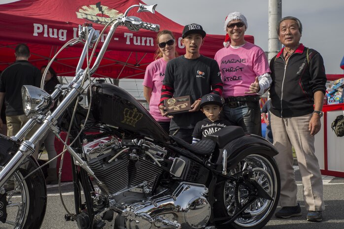 Daigiroh Akiyama, winner of the best bike, poses with the event coordinators of the third-annual Toy Drive and Motorcycle Rally at the Marine Thrift Store at Marine Corps Air Station Iwakuni, Japan, Nov. 22, 2015. Station residents and Japanese and American motorcycle riders decked-out their bikes with Christmas decorations and donated toys for Japanese orphans.