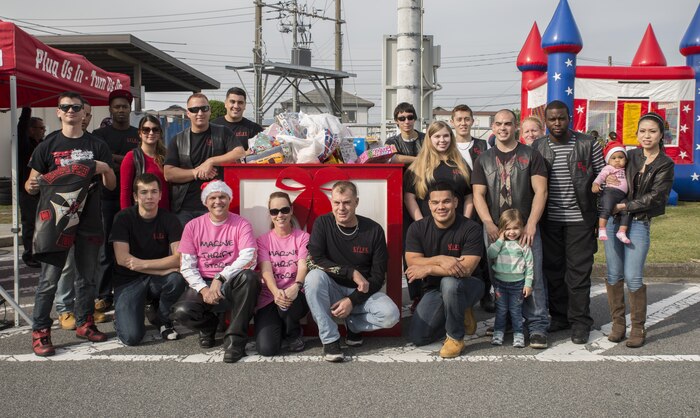 Members of the Endangered Species Motorcycle Club pose by the gift box during the third-annual Toy Drive and Motorcycle Rally at the Marine Thrift Store Nov. 22, 2015, at Marine Corps Air Station Iwakuni, Japan. Japanese motorcycle clubs, riders from the air station and station residents attended the event to donate toys for Japanese orphans and to participate in contests from best decorated bike to furthest traveled.