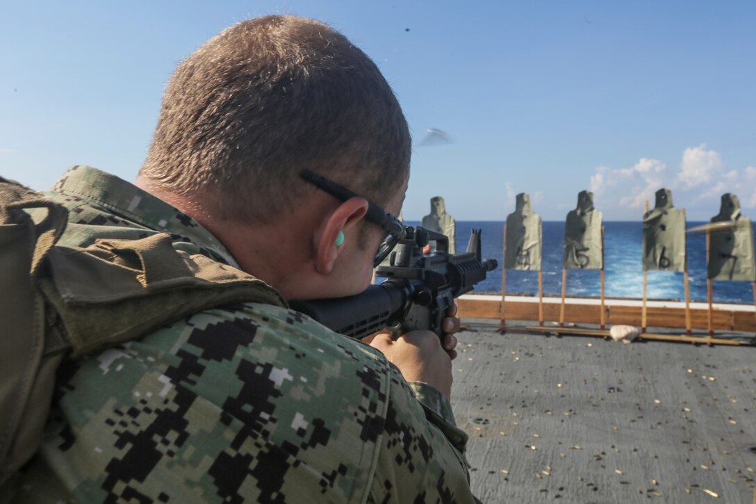 U.S. Navy Petty Officer 2nd Class Curran Kay fires an M4 carbine during a deck shoot aboard the USS Anchorage.  Kay is an engineman with the rigid-hull inflatable boat detachment, 15th Marine Expeditionary Unitin the South China Sea, Nov. 14, 2015.  The 15th MEU is currently deployed in the Indo-Asia-Pacific region to promote regional stability and security in the U.S. 7th Fleet area of operations 