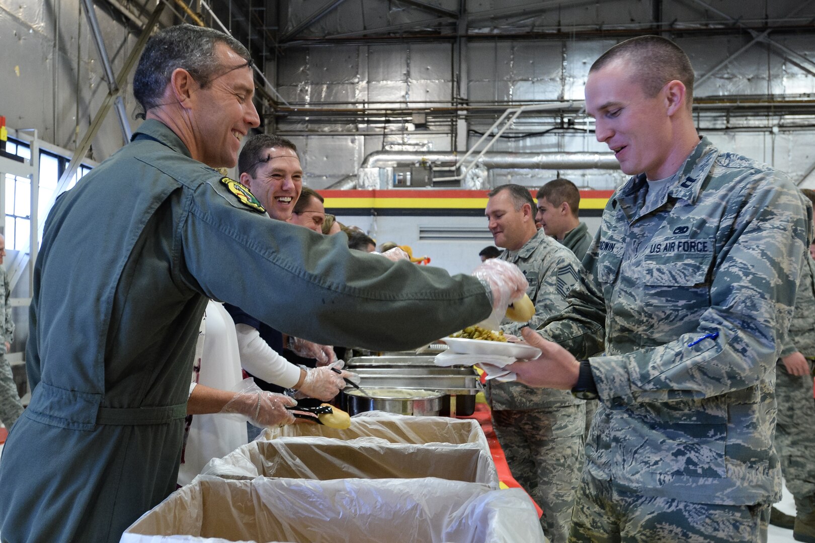 Col. David Smith (left), 419th Fighter Wing commander, helps serve a Thanksgiving meal to Airmen assigned to Hill Air Force Base's fighter wings here Nov. 24. With help from the local community, hundreds of Airmen in the 419th FW and active-duty 388th FW feasted together in celebration of the holiday. (U.S. Air Force photo/R. Nial Bradshaw) 