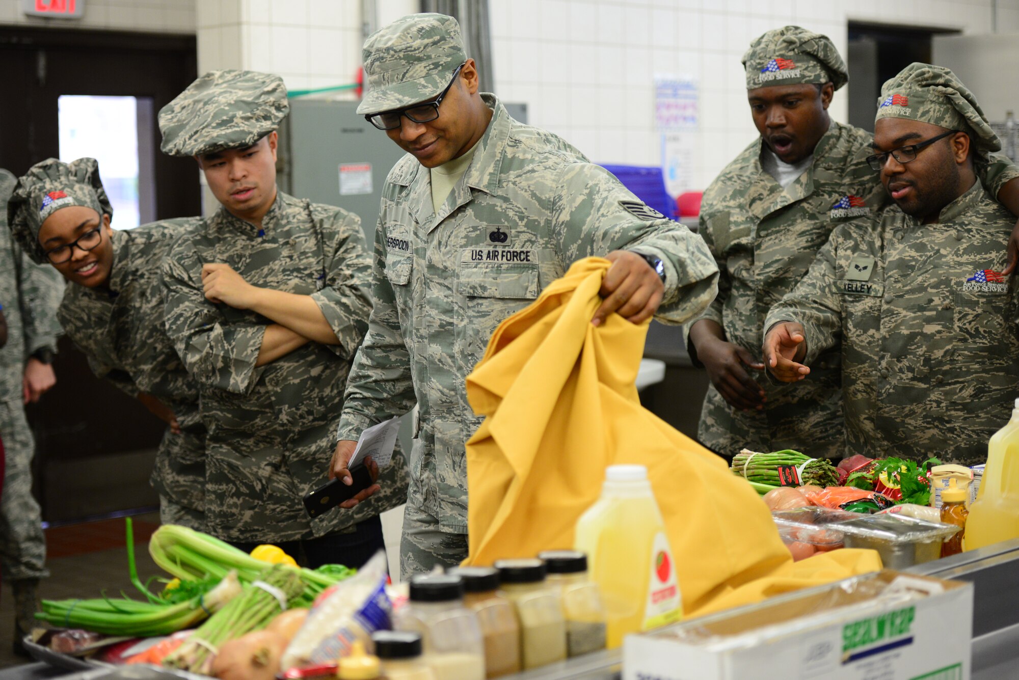 Secret cooking ingredients are reveled just minutes before the cooking portion of the bi-annual Force Support Squadron Challenge kicks off at Osan Air Base, Republic of Korea, Nov. 20, 2015. FSS Airmen from both Osan and Kunsan AB were required to make a three-course meal which included pomegranates, butternut squash and spicy cheese-flavored cornmeal pieces. (U.S. Air Force photo/Staff Sgt. Amber Grimm)