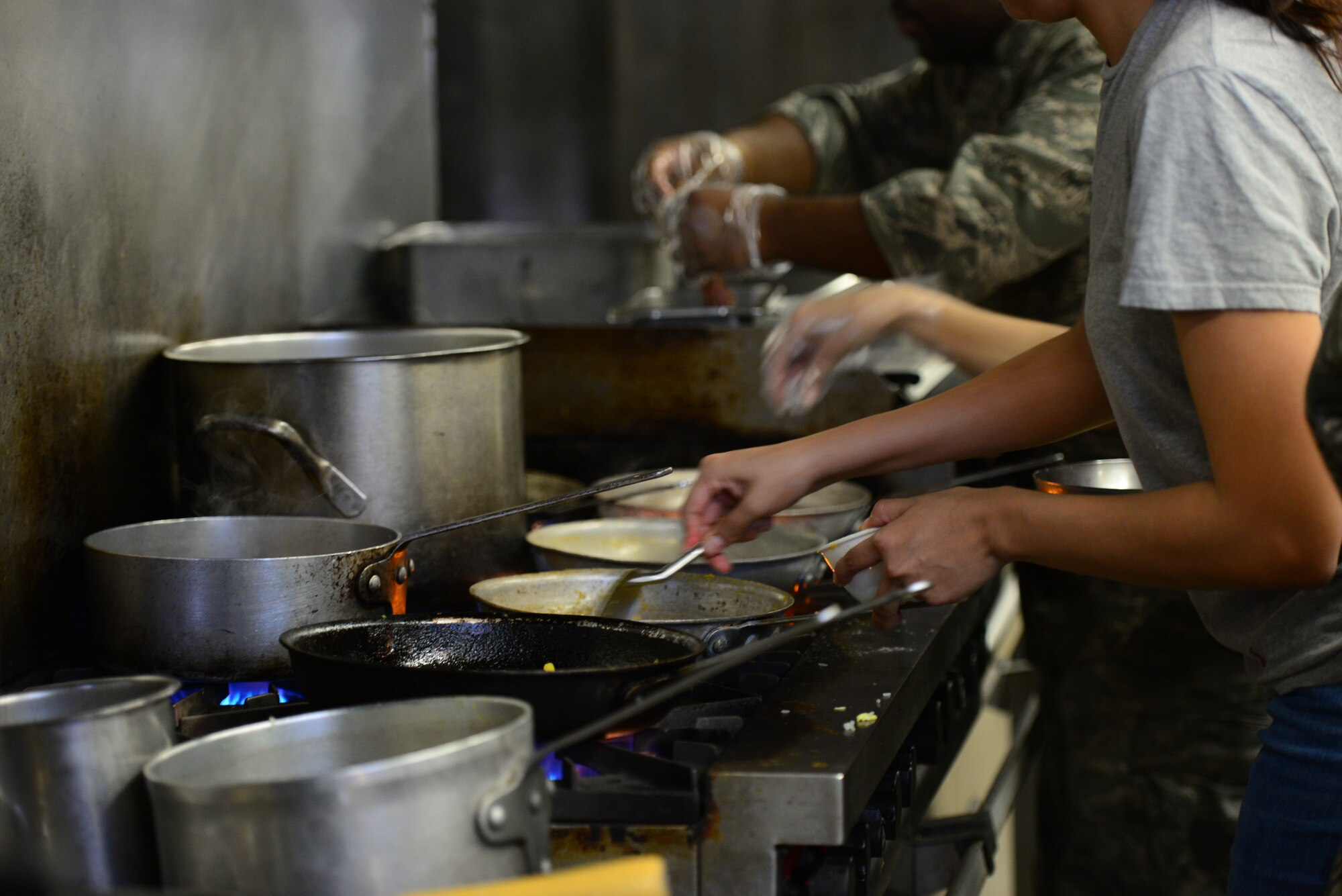 Pots and pans pile up as the four-man teams from Osan and Kunsan Air Bases battle for stove space during the bi-annual Force Support Squadron challenge held at Osan AB, Republic of Korea, Nov. 20, 2015. Each team had one hour to prepare a three-course meal before being judged on taste, presentations and individual courses. (U.S. Air Force photo/Staff Sgt. Amber Grimm)