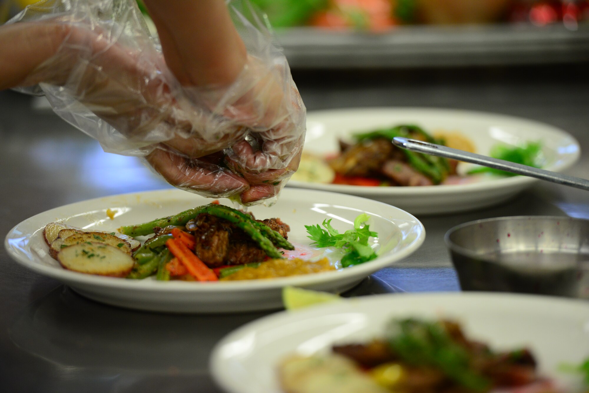 Finishing touches are added to a three-course meal prepared by Airmen from the force support squadron of Kunsan Air Base for the bi-annual FSS Challenge held at Osan Air Base, Republic of Korea, Nov. 20, 2015. Each team had only one hour to prepare  meals that would be judged on taste, presentation and best individual course. (U.S. Air Force photo/Staff Sgt. Amber Grimm)