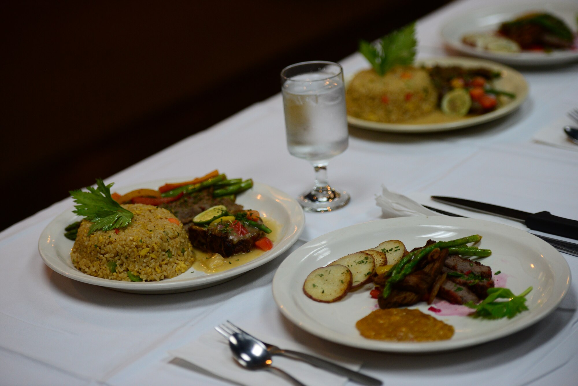 Dishes prepared by the Airmen from Kunsan and Osan’s force support squadron sit side-by-side on the judge’s table during the bi-annual FSS Challenge held at Osan Air Base, Republic of Korea, Nov. 20, 2015.  The Airmen were required to prepare a three-course meal using limited ingredients, which included the surprise ingredients: pomegranates, butternut squash and spicy cheese-flavored cornmeal pieces. (U.S. Air Force photo/Staff Sgt. Amber Grimm)