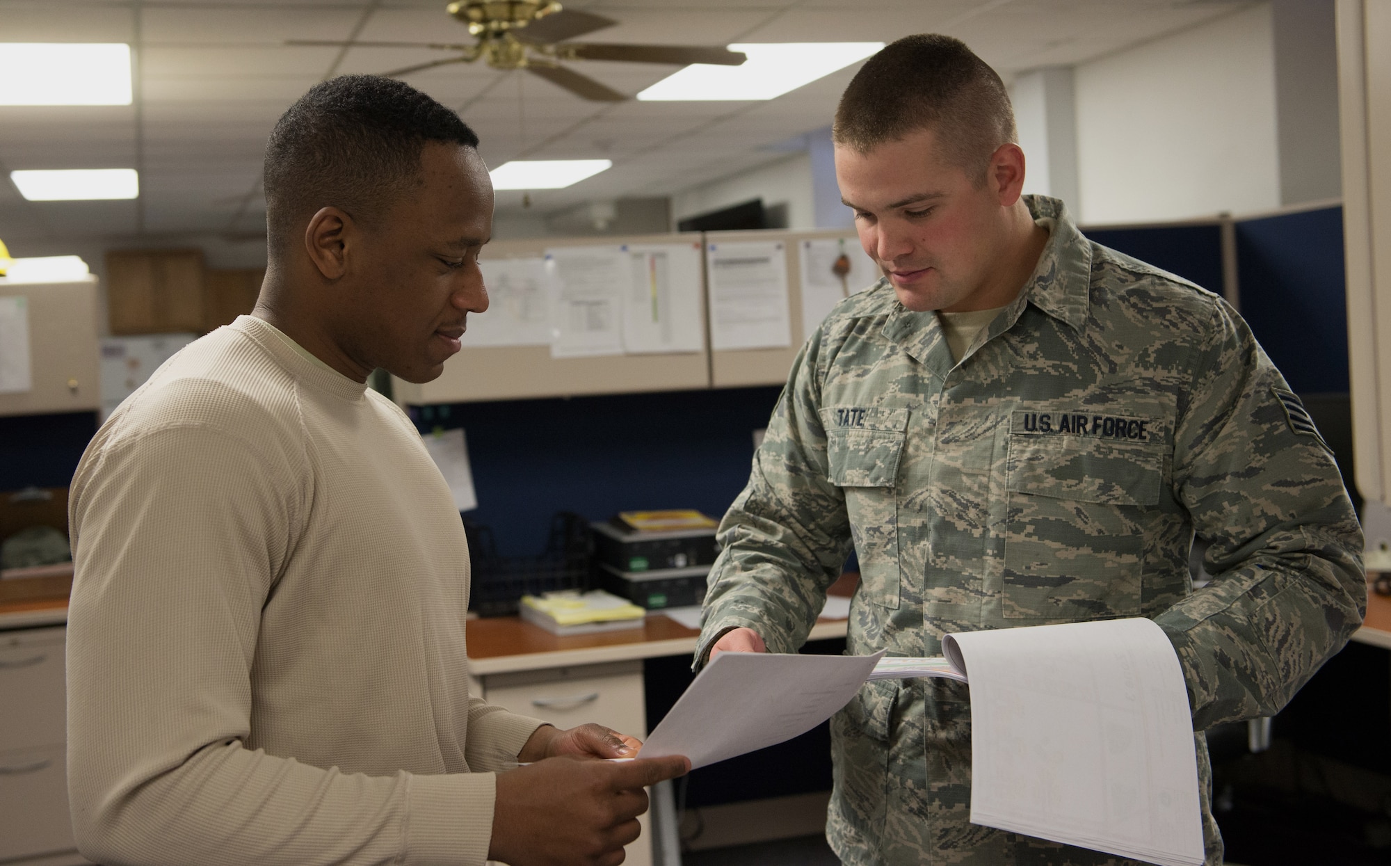 U.S. Air Force Senior Airman Keathon Malone Jr., a 354th Civil Engineer Squadron requirements and optimization specialist, asks Staff Sgt. Mitchell Tate, a water, fuels and systems maintenance specialist with the 354th CES, a question Nov. 16, 2015, at Eielson Air Force Base, Alaska. Malone received instructions on manhole points Tate needs on the maps. (U.S. Air Force photo by Airman 1st Class Cassandra Whitman/Released)