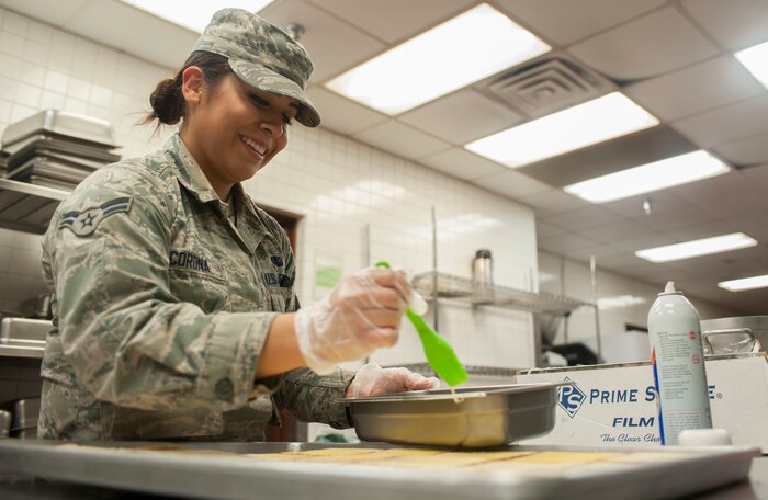 Airman 1st Class Natalie Corona, 99th Force Support Squadron food service apprentice, prepares garlic bread to be served for dinner at the Crosswinds Dining Facility on Nellis Air Force Base, Nev., Nov. 18, 2015.  The Crosswinds DFAC will be serving Thanksgiving meals to Airmen and Department of Defense ID cardholders on Thanksgiving Day, Nov. 26. (U.S. Air Force photo by Senior Airman Mikaley Kline)