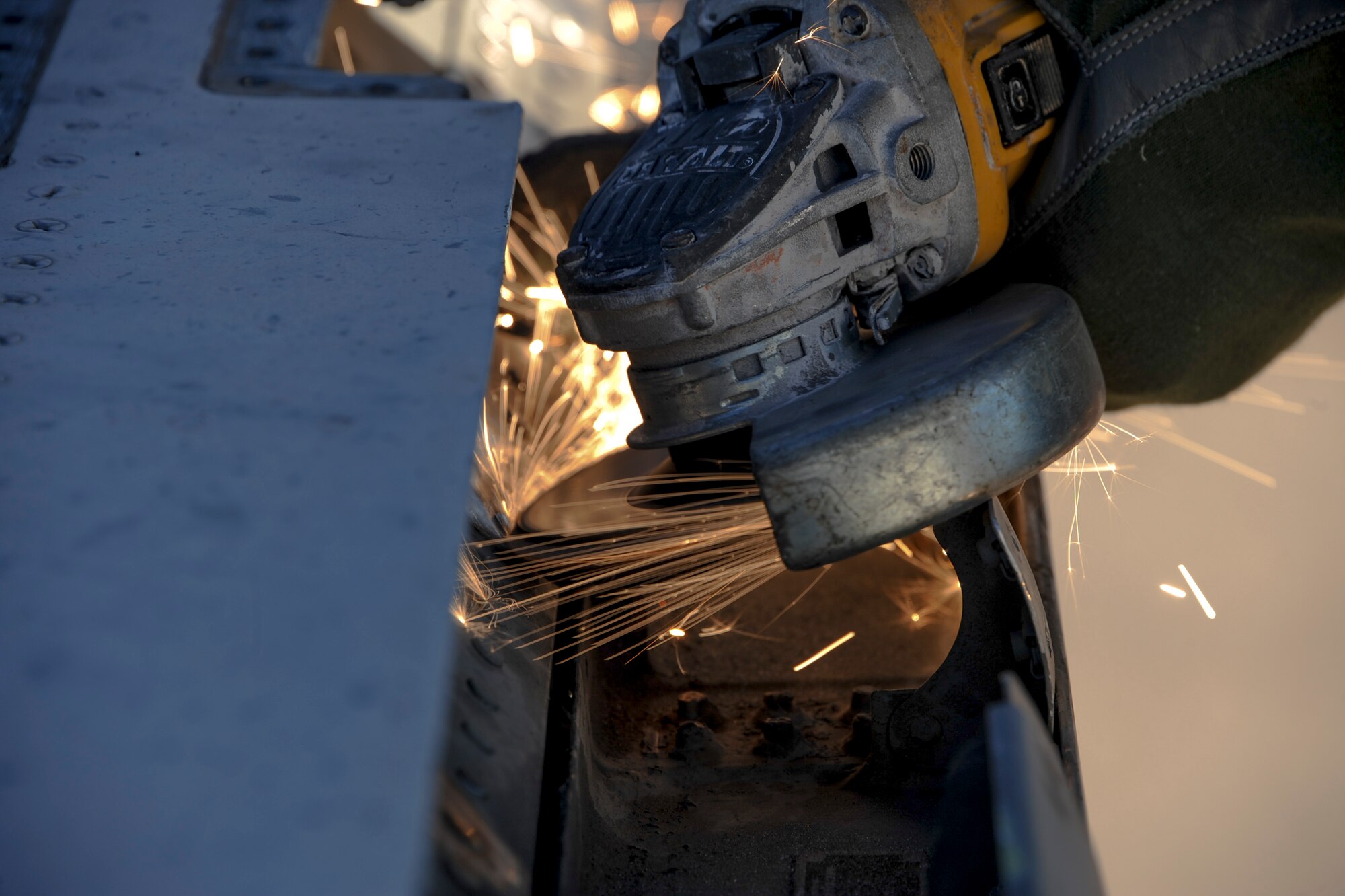 Tim Amalong, airframe mechanic, grinds bolts on an F-15A Eagle on the flightline at Davis-Monthan Air Force Base, Ariz., Nov. 19, 2015. A team of contractors, including Amalong, took five days to completely disassemble the aircraft and load it onto two flatbed trucks to be shipped to Joint Base Lewis-McChord, Wash., for display. The entire project is estimated to take approximately eight months from the planning stage to finish. (U.S. Air Force photo by Airman Basic Nathan H. Barbour/Released)