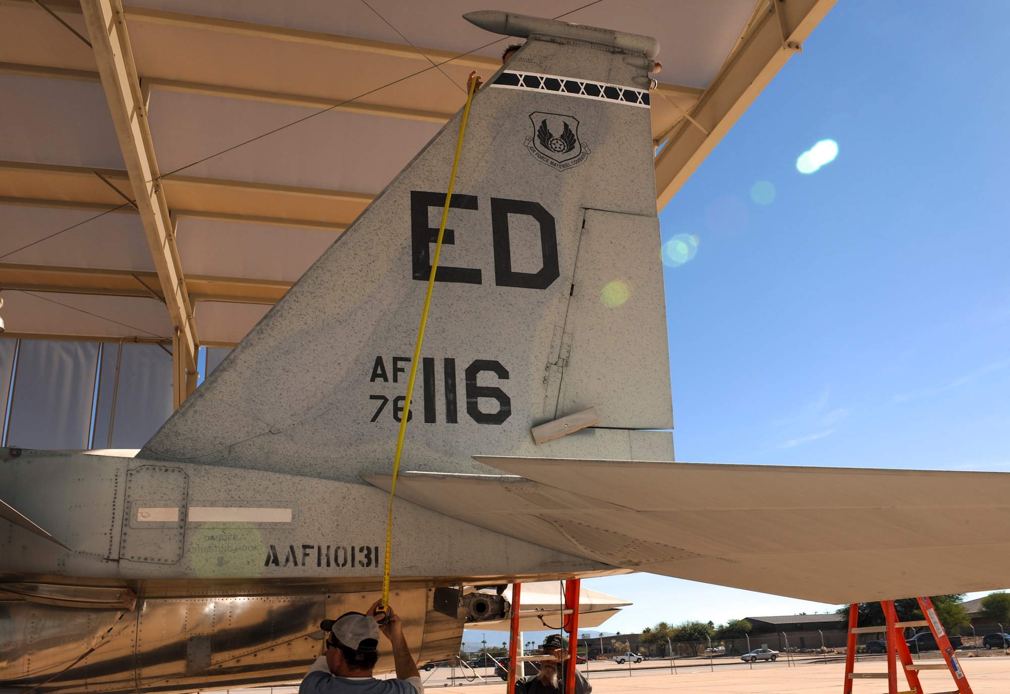 A team of contractors measure the height of an F-15A Eagle vertical stabilizer on the flightline at Davis-Monthan Air Force Base, Ariz., Nov. 18, 2015.  The team took five days to completely disassemble the aircraft and load it onto two flatbed trucks to be shipped to Joint Base Lewis-McChord, Wash., for display. The entire project is estimated to take approximately eight months from the planning stage to finish. (U.S. Air Force photo by Airman Basic Nathan H. Barbour/Released)