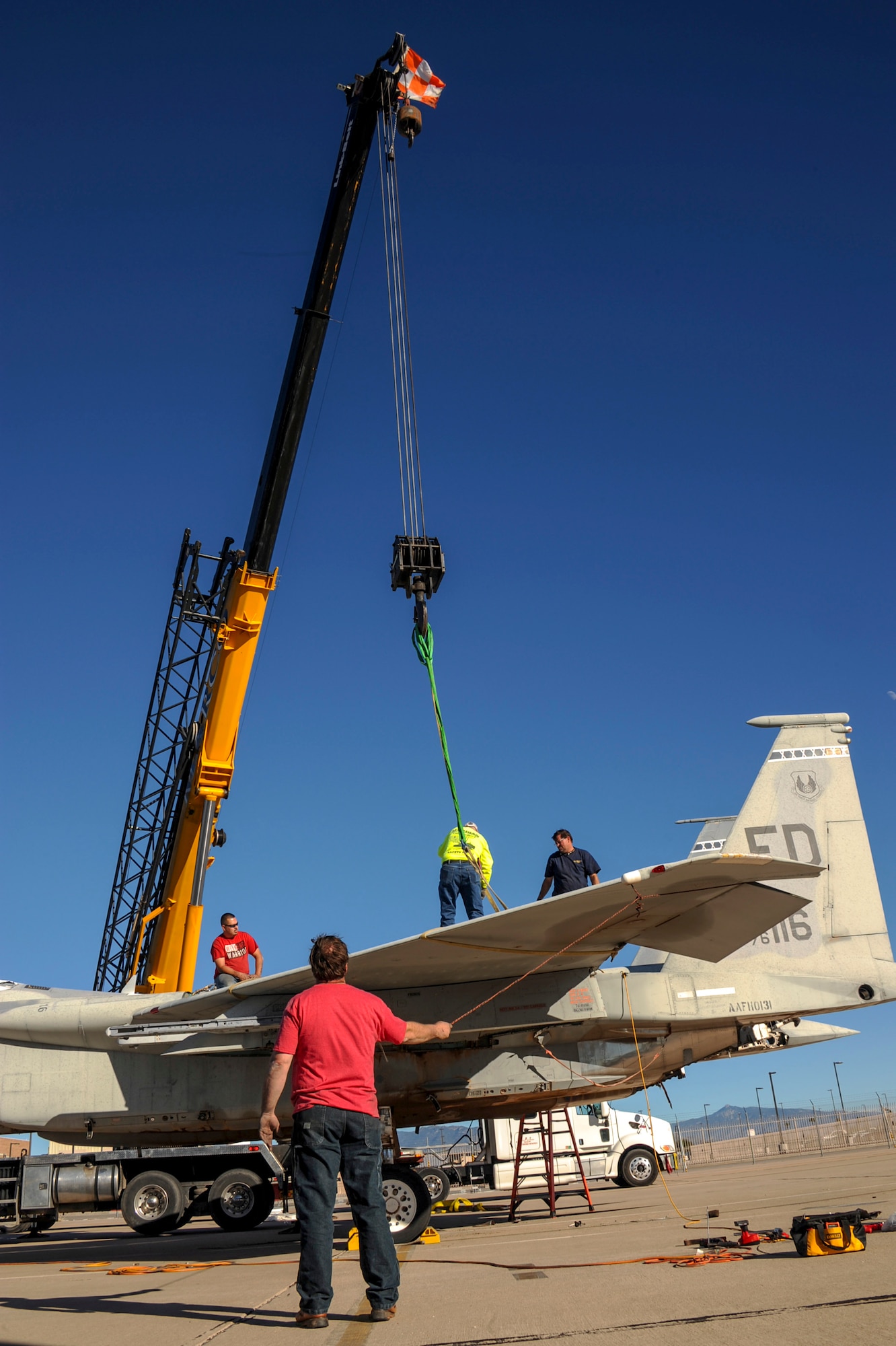 A team of contractors prepare to remove a wing from an F-15A Eagle on the flightline at Davis-Monthan Air Force Base, Ariz., Nov. 19, 2015. The team of contractors took five days to completely disassemble the aircraft and load it onto two flatbed trucks to be shipped to Joint Base Lewis-McChord, Wash., for display. The entire project is estimated to take approximately eight months from the planning stage to finish. (U.S. Air Force photo by Airman Basic Nathan H. Barbour/Released)