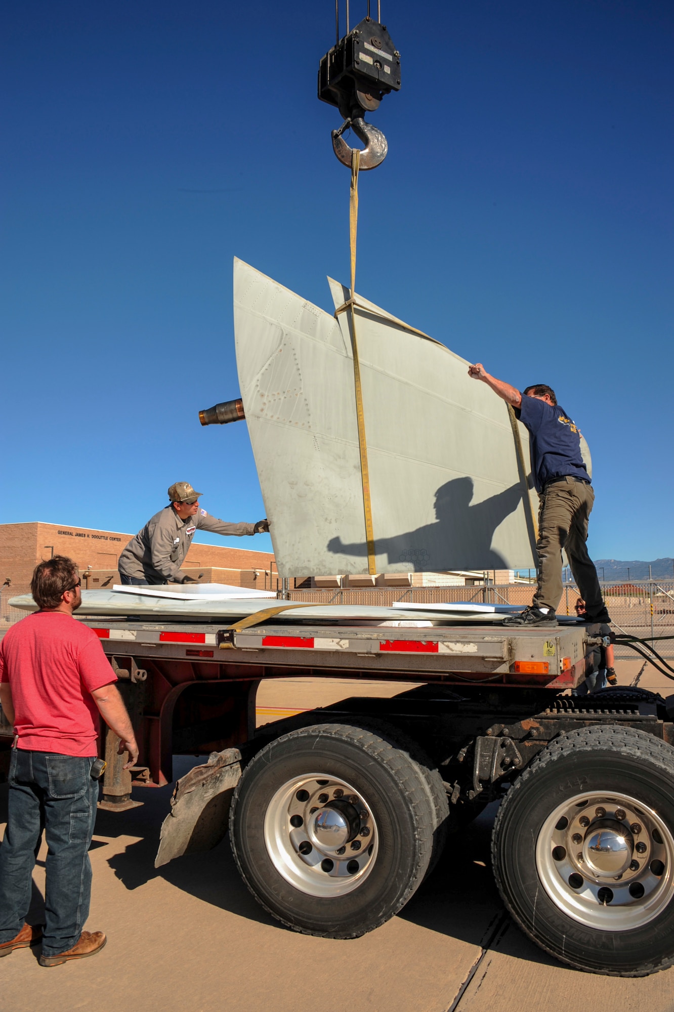 A team of contractors load an F-15A Eagle horizontal stabilizer onto a flatbed truck on the flightline at Davis-Monthan Air Force Base, Ariz., Nov. 19, 2015. The team took five days to completely disassemble the aircraft and load it onto two flatbed trucks to be shipped to Joint Base Lewis-McChord, Wash., for display. The entire project is estimated to take approximately eight months from the planning stage to finish. (U.S. Air Force photo by Airman Basic Nathan H. Barbour/Released)