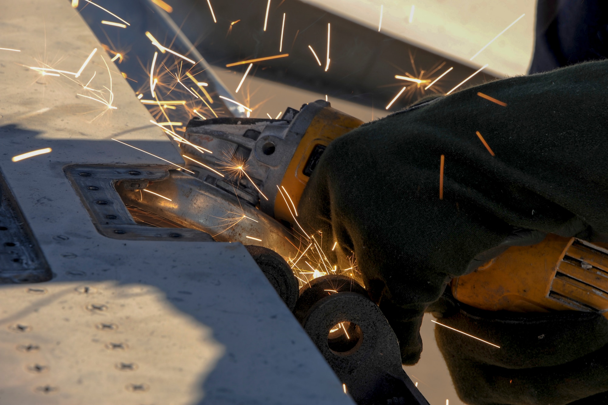 Tim Amalong, airframe mechanic, grinds bolts on an F-15A Eagle on the flightline at Davis-Monthan Air Force Base, Ariz., Nov. 19, 2015. A team of contractors, including Amalong, took five days to completely disassemble the aircraft and load it onto two flatbed trucks to be shipped to Joint Base Lewis-McChord, Wash., for display. The entire project is estimated to take approximately eight months from the planning stage to finish. (U.S. Air Force photo by Airman Basic Nathan H. Barbour/Released)