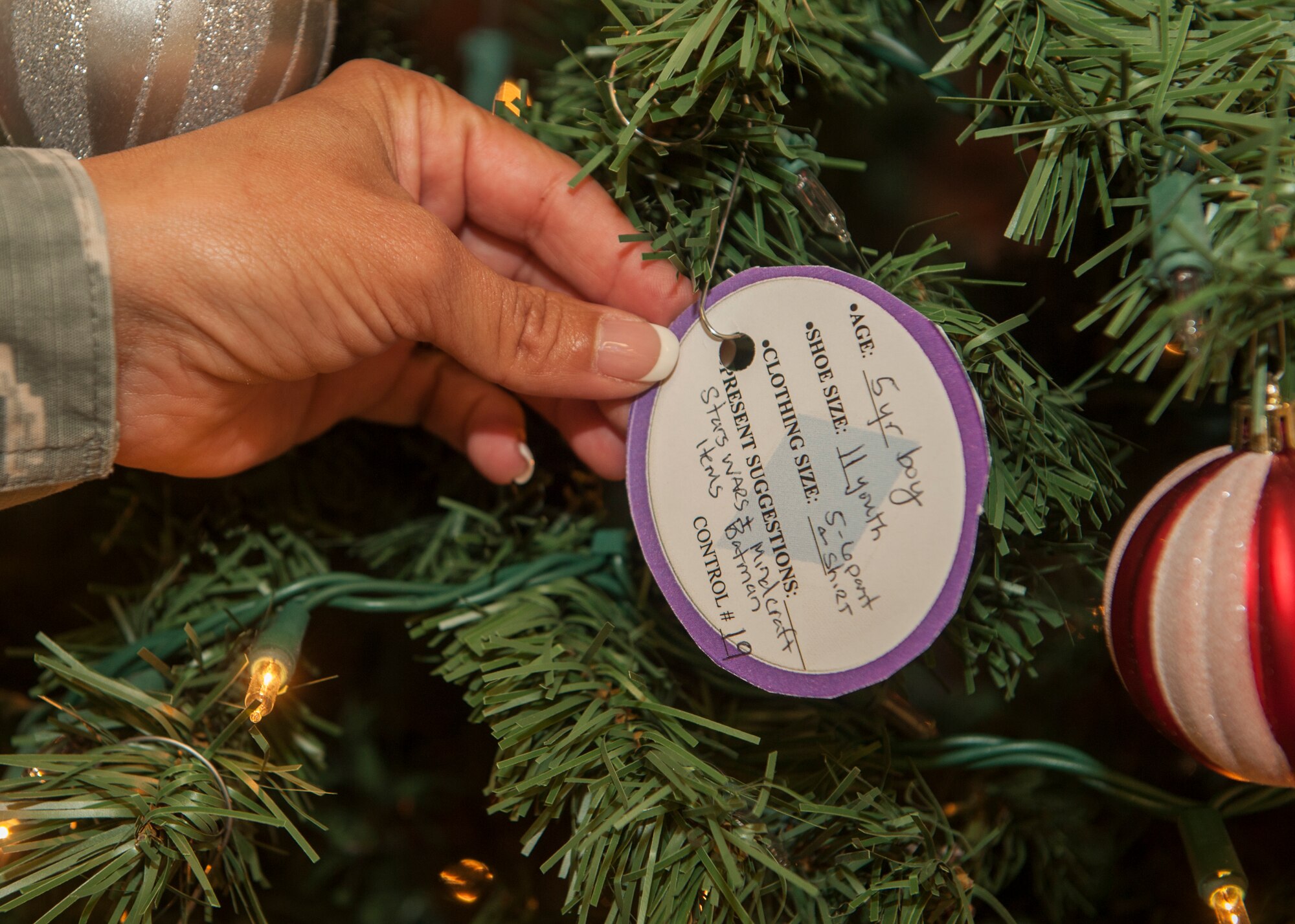 Master Sgt. Arwa Cavender, 49th Material Maintenance Squadron first sergeant, hangs an ornament on the Diamond Tree located in the Base Exchange at Holloman Air Force Base, N.M., November 24. The Diamond Tree program provides gifts for children at Holloman in single income homes and other families in need. (U.S. Air Force photo by Airman 1st Class Randahl J. Jenson)  