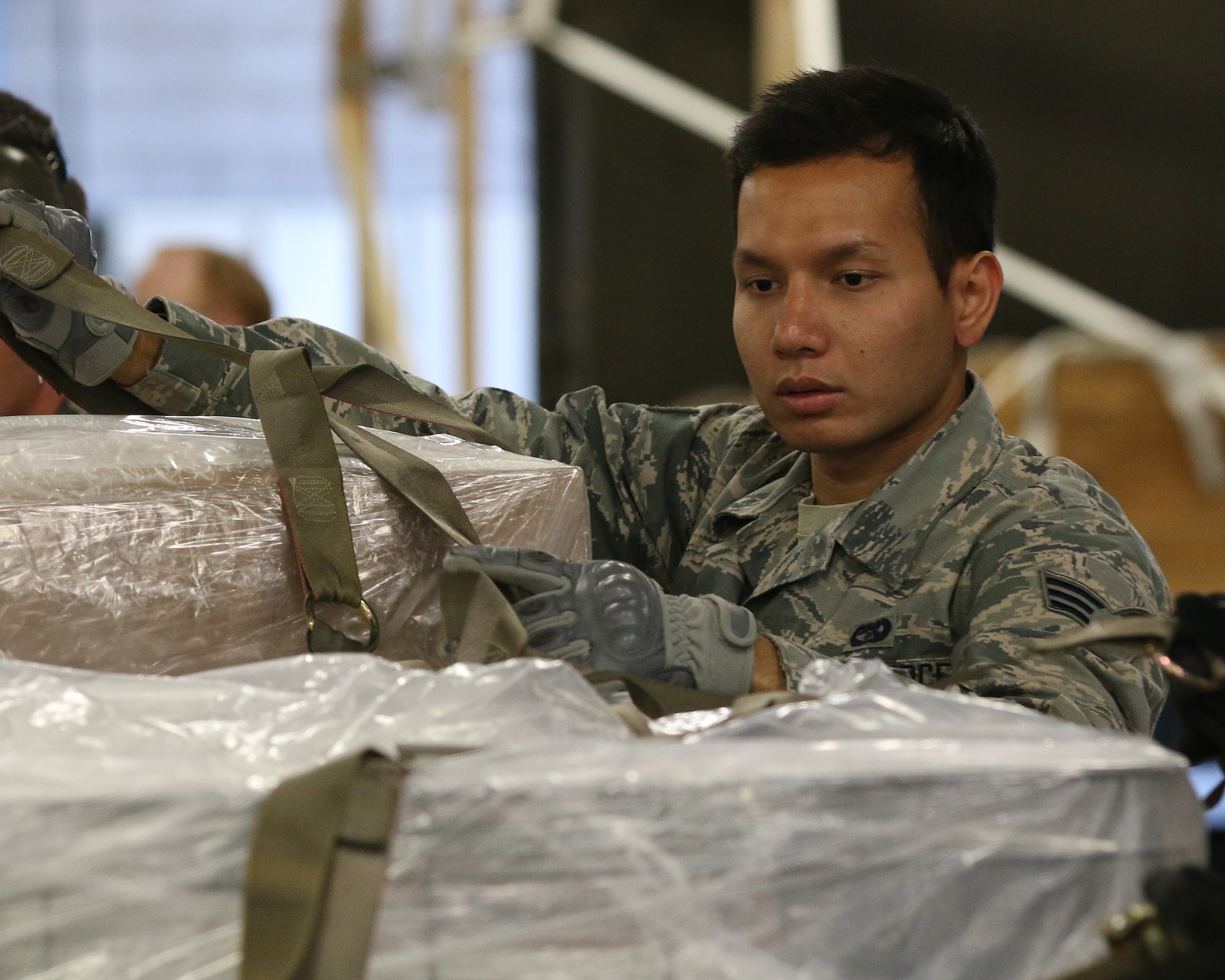 WRIGHT-PATTERSON AIR FORCE BASE, Ohio – Senior Airman Ney Htet, 87th Aerial Port Squadron cargo processor, connects cargo straps onto pallets simulated for transportation by C-17 Globemaster III during training held on the Nov. 6, 2015 unit training assembly. (U.S. Air Force photo /Tech. Sgt. Patrick O’Reilly)